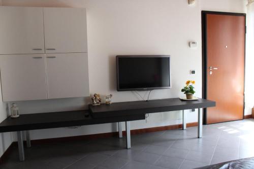 - un salon avec une table et une télévision dans l'établissement Alex's lake house, à Riva di Solto