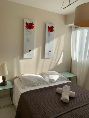 een slaapkamer met een bed met rode rozen aan de muur bij Port Plage Centre Ville et Soleil in Saint-Raphaël
