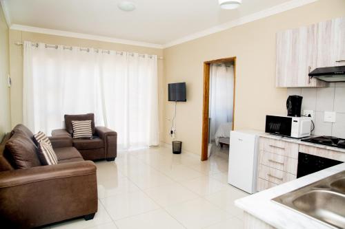 a living room with a couch and a kitchen at AS Guesthouse & Self-catering in Swakopmund