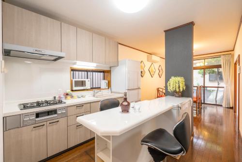 a kitchen with a white counter and chairs in it at JR 66sqm 1F Family Suite 2LDK JR Koiwa-Keisei Koiwa-Asakusa-Oshiage-Shinjuku-Ueno in Tokyo