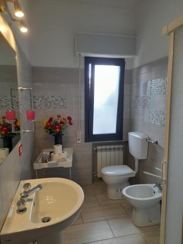 a bathroom with a sink and a toilet and a window at Appartamento ORNELLO in Pietrasanta