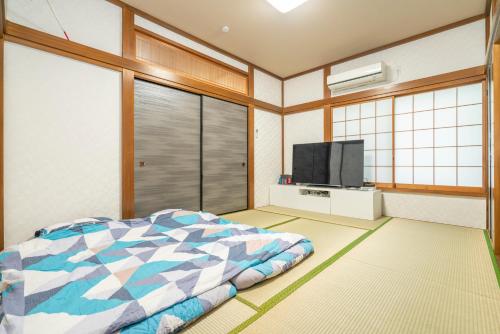 a bedroom with a bed and a flat screen tv at JR 66sqm 1F Family Suite 2LDK JR Koiwa-Keisei Koiwa-Asakusa-Oshiage-Shinjuku-Ueno in Tokyo