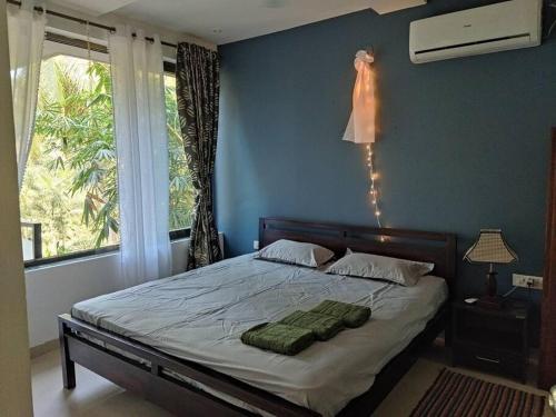 a bedroom with a bed with green towels on it at Palolem Luxury Apartments in Canacona