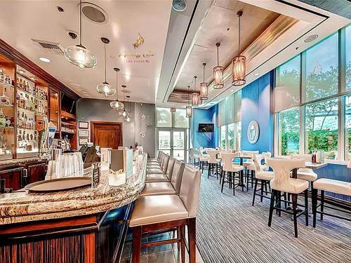 a restaurant with a bar and tables and chairs at Amalz 2 Bedroom 3 Bathroom Balcony Suites at Mgm Signature ! in Las Vegas