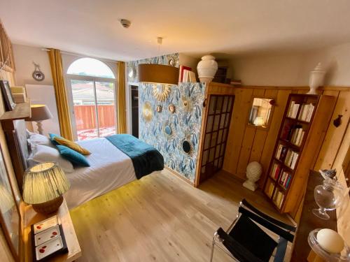 een slaapkamer met een bed en een groot raam bij Hôtel Le Caillebotis in Cap-Ferret