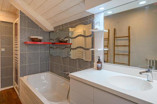 La salle de bains est pourvue d'une baignoire et d'un lavabo. dans l'établissement Imagine - Charmante maison avec jardin, à Vannes