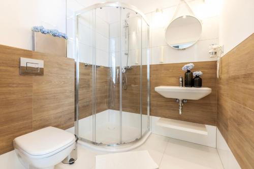 a bathroom with a shower and a toilet and a sink at VacationClub - Boulevard Residence Apartament 33 in Ustronie Morskie