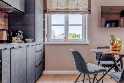 uma cozinha com mesa e cadeiras e uma janela em Living Lorens No 6 em Westerland