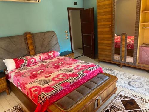 a bedroom with a bed with a red blanket on it at Luxury apartment in front of the AUC in Cairo