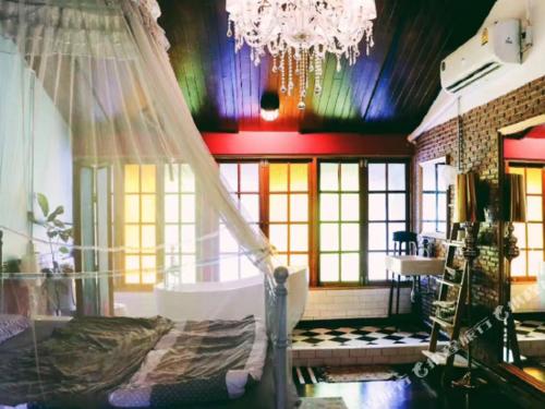 a room with a bed and a chandelier at T-House BKK 2Floors near BTS with swimming pool and free Wifi in Klong Toi
