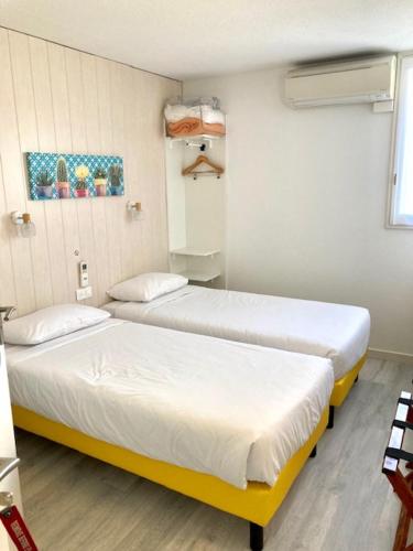a room with two beds in a room at Logis Hôtel- Hôtel Restaurant Le Rialto in Le Sequestre