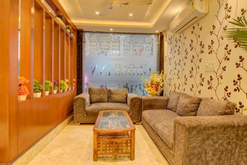 a living room with two couches and a coffee table at FabHotel Gross Inn Suites in New Delhi