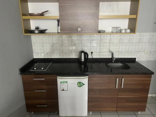 una pequeña cocina con fregadero y nevera. en Maren City Apart Hotel, en Alanya