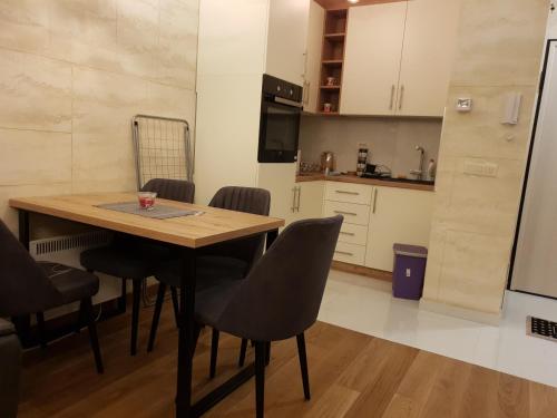 a kitchen and dining room with a table and chairs at Balkan Hill 3 - Apartman TORG in Zlatibor