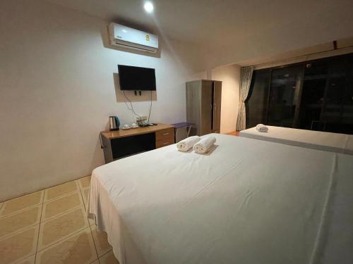 - une chambre avec un lit blanc et des serviettes dans l'établissement 95 restaurant, à Nai Thon Beach