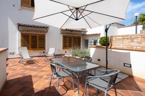 patio con tavolo, sedie e ombrellone di Casa Ibiscus a Mondello
