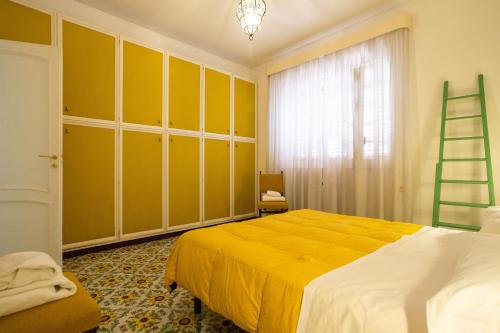 a bedroom with a yellow bed and a ladder at Casa Ibiscus in Mondello