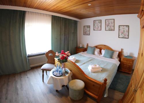 Un dormitorio con una cama y una mesa con flores. en Zum Burgkeller, en Bruchweiler