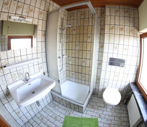 a bathroom with a sink and a shower and a toilet at Zum Burgkeller in Bruchweiler