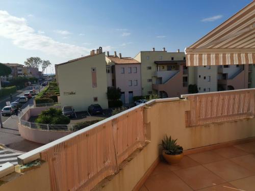 balkon z drewnianym płotem i budynkami w obiekcie Archipel II- 30C - Appart moderne - 6 pers w Cap d'Agde