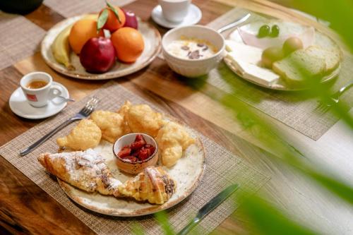 einem Holztisch mit Teller mit Lebensmitteln darauf in der Unterkunft Elegance Boutique Hotel in Korçë