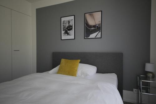a bedroom with a bed with a yellow pillow on it at VARIAS Lifestyle Apartments in Elsau