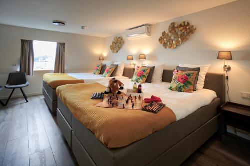 a bedroom with two beds with chessetts on the bed at Bed and Breakfast De Heren van Valkenburg in Valkenburg