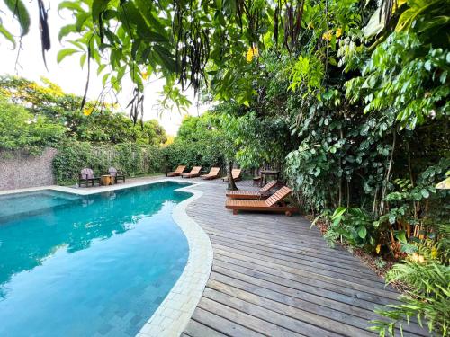 einen Pool mit Bänken auf einer Holzterrasse in der Unterkunft Pousada Mangue Sereno in Caraíva