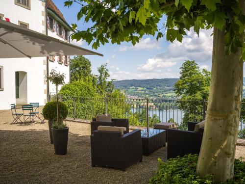 a patio with chairs and a view of the water at Schloss Freudenfels in Eschenz