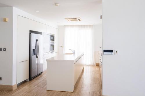 a white kitchen with a sink and a refrigerator at AAA SEAVIEW PANORAMA in Pervolia