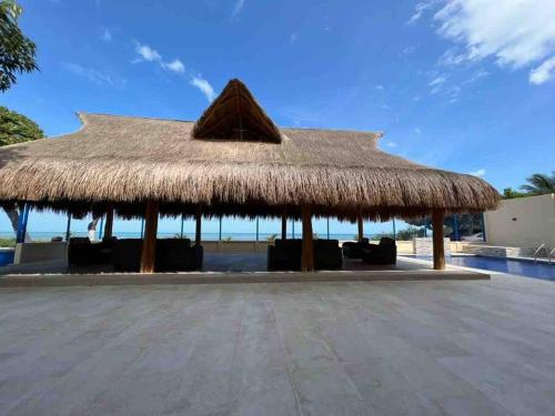 a straw roofed pavilion next to a swimming pool at Dianamar house, Te mereces disfrutarlo in Ríohacha