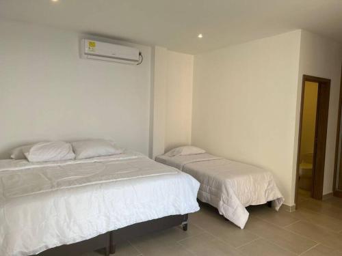 a bedroom with two beds and a air conditioner at Dianamar house, Te mereces disfrutarlo in Ríohacha