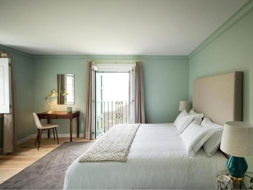 1 dormitorio con 1 cama blanca, escritorio y ventana en Quinta da Gricha, en Ervedosa do Douro