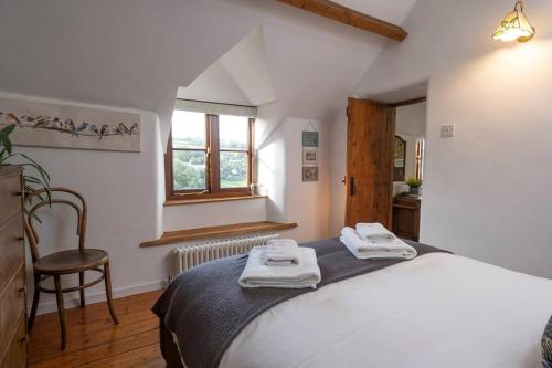 a bedroom with a bed with towels on it at Cosy Country Cottage with Stunning Views in Nailsworth in Nailsworth