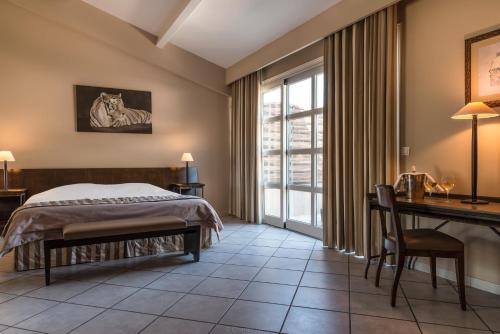 a bedroom with a bed and a desk at Hôtel la Magnaneraie in Villeneuve-lès-Avignon