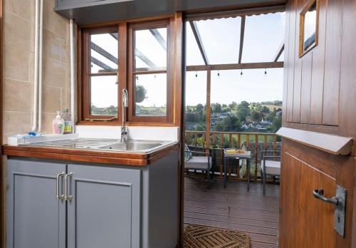 a kitchen with a sink and a large window at Cosy Country Cottage with Stunning Views in Nailsworth in Nailsworth