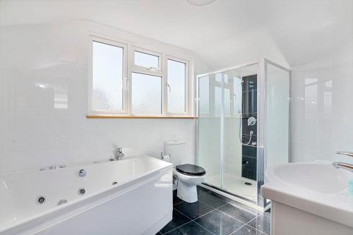 a white bathroom with a toilet and a sink at Modern 8-Bed Home - Parking, Wi-Fi, 5 mins to Town in Gravesend