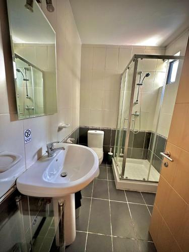 een badkamer met een wastafel en een douche bij Dhalia Apartments - St. Julians in St Julian's