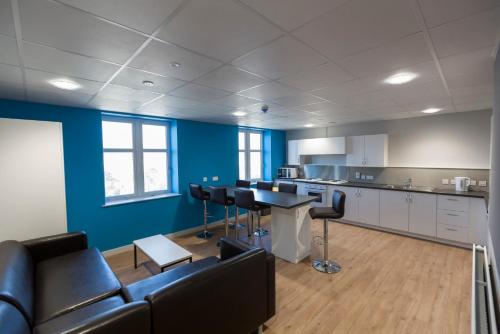 um quarto com um sofá, uma mesa e uma cozinha em Ensuite Bedrooms with Shared Kitchen at Bay Campus located in Swansea em Swansea