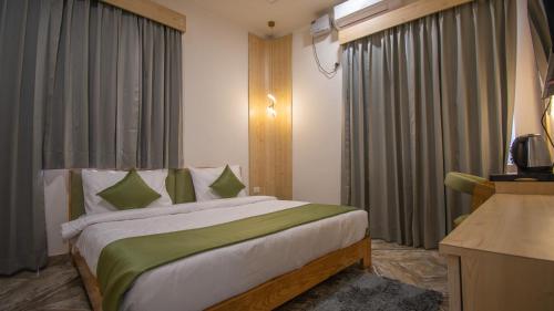 a bedroom with a large bed in a room with curtains at Around Stays Rishikesh, Tapovan in Rishīkesh