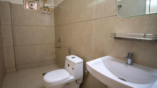 a bathroom with a white toilet and a sink at Around Stays Rishikesh, Tapovan in Rishīkesh