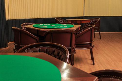 a group of tables and chairs with green poker chips on them at Marques Plaza Hotel in Pouso Alegre