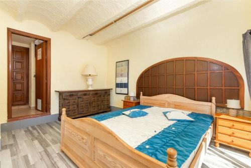 a bedroom with a large wooden bed and a wooden dresser at Villa Bonaventura in Calonge