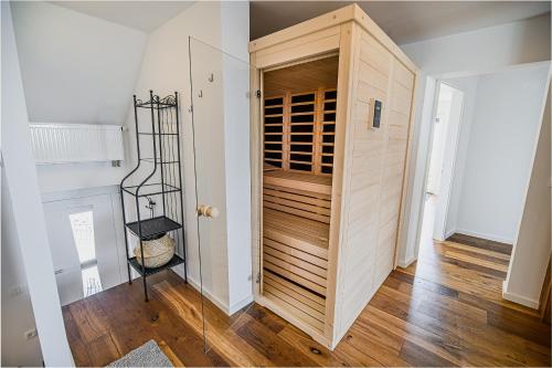 a room with a wooden cabinet with wine bottles at Mountain View Apartment with Sauna in Cerklje na Gorenjskem