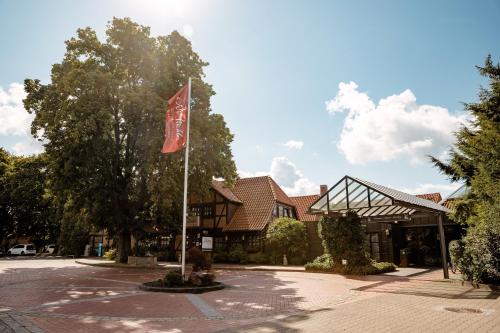 a flag on a pole in front of a building at Privathotel alte mühle Wolfsburg-Weyhausen in Wolfsburg