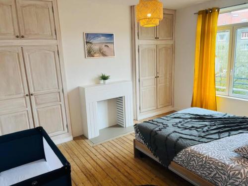 een slaapkamer met een bed en een open haard bij « Bel’ Epoque » proche vieille ville 6 pers, WIFI in Boulogne-sur-Mer
