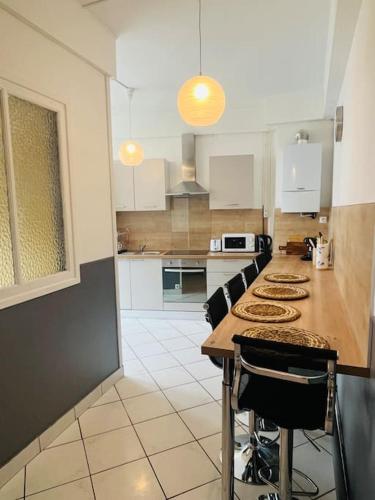 une cuisine avec une table et des chaises dans l'établissement « Bel’ Epoque » proche vieille ville 6 pers, WIFI, à Boulogne-sur-Mer