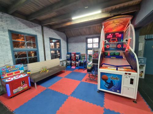 a room with a video game machine and a bench at Chalet Panorama near Efteling - with garden and swimmingpool Europarcs in Kaatsheuvel