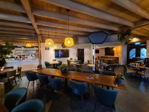 a restaurant with a large wooden table and chairs at Chalet Panorama near Efteling - with garden and swimmingpool Europarcs in Kaatsheuvel