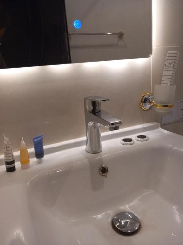 a white sink with a faucet and a mirror at دايموند Diamond in AlUla